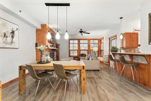 a dining room and living room with a table and chairs at Les Eaux 225-1 by Escapades Tremblant in Mont-Tremblant