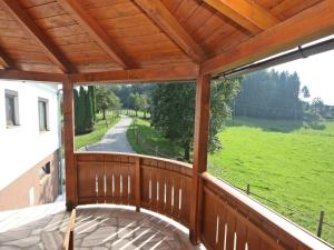 eine Holzveranda mit Blick auf ein grünes Feld in der Unterkunft Holiday Home Berg by Interhome in Obermieger
