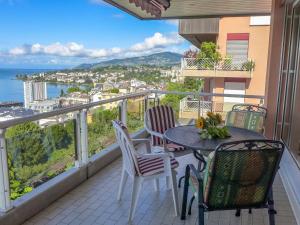 蒙特勒的住宿－Apartment Montreux - Panorama by Interhome，阳台配有桌椅,享有海景。