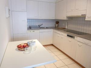 een witte keuken met een fruitschaal op een aanrecht bij Apartment Montreux - Panorama by Interhome in Montreux