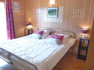 a bedroom with a large white bed with two pillows at Chalet Ropiar by Interhome in Ovronnaz