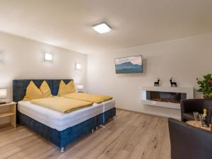 1 dormitorio con 1 cama extragrande y chimenea en Appartementhaus FICHTERN, en Sankt Johann in Tirol
