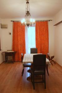 a dining room with a table and orange curtains at Velvet Apartament Kopińska in Warsaw