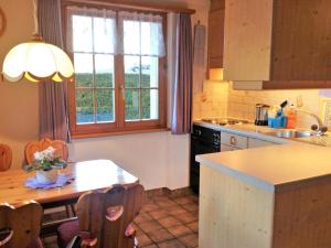 een keuken met een tafel en een raam erin bij Apartment Lohnerhus-1 by Interhome in Grindelwald