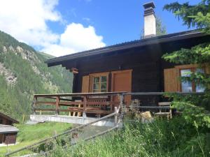 a log cabin with a porch on a mountain at Chalet Coquelicot by Interhome in Zinal