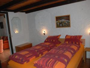 a bedroom with two beds with red and orange pillows at Holiday Home Rustico Cristallo by Interhome in Aquila