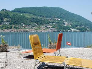 twee stoelen op een richel met uitzicht op het water bij Apartment Casa Zappa by Interhome in Brusino Arsizio
