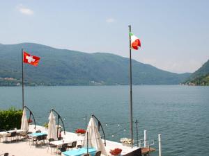 due bandiere canadesi che volano sopra un lago con tavoli e sedie di Apartment Casa Zappa by Interhome a Brusino Arsizio