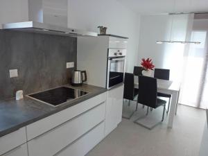 a kitchen with white cabinets and a table with chairs at Apartment Brake by Interhome in Offenburg