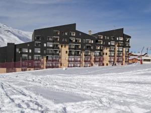 um grande edifício no topo de um campo coberto de neve em Apartment Le Villaret-8 by Interhome em Les Menuires