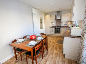 a kitchen with a wooden table and chairs in a room at Holiday Home Devonvale Place by Interhome in Kinross