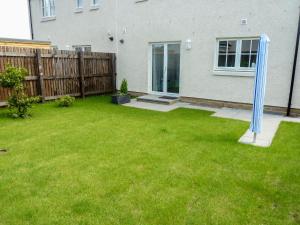 a yard with a blue gazebo in the grass at Holiday Home Devonvale Place by Interhome in Kinross