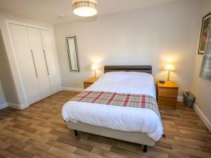 a bedroom with a bed and two night stands and two lamps at Holiday Home Devonvale Place by Interhome in Kinross