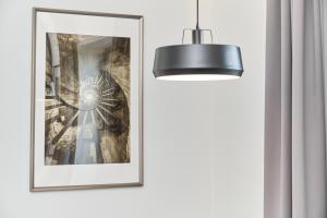a picture frame on a wall next to a lamp at Eleganckie Studia Wyspa Słodowa by Noclegi Renters in Wrocław +16 photos