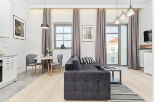 a living room with a black couch and a table at Eleganckie Studia Wyspa Słodowa by Noclegi Renters in Wrocław