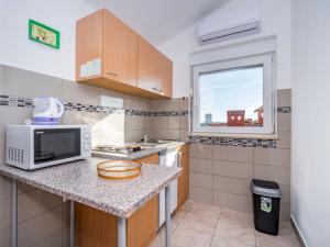a kitchen with a counter with a microwave and a window at Apartment B&B-6 by Interhome in Ližnjan