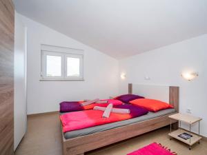 a bedroom with a large bed with red and purple blankets at Apartment B&B-6 by Interhome in Ližnjan