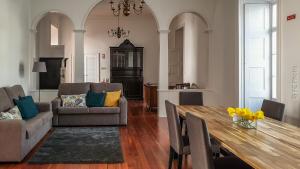 a living room with a dining table and a kitchen at CC Guest House - "Ao Mercado" in Ponta Delgada