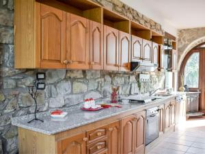 kuchnia z drewnianymi szafkami i kamienną ścianą w obiekcie Villa Tenuta Valente by Interhome w mieście Giungano +37 zdjęć