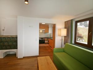 uma sala de estar com um sofá verde e uma janela em Holiday Home Happy by Interhome em Eben im Pongau