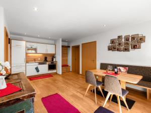 eine Küche und ein Wohnzimmer mit einem Holztisch und Stühlen in der Unterkunft Apartment Mooslehen-1 by Interhome in Schattberg