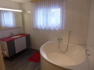 un bagno bianco con vasca e lavandino di Apartment Amici 1- Stock Allegra by Interhome a Riederalp