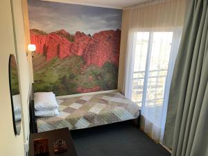 a bedroom with a painting on the wall next to a bed at Guest house and yurt camp "Aktan" in Bokonbayevo +78 photos