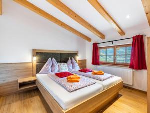 - une chambre avec 2 lits et des oreillers rouges dans l'établissement Apartment Mooslehen-3 by Interhome, à Schattberg