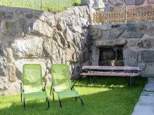 two chairs and a bench in front of a stone wall at Apartment Wildbachl by Interhome in Aschau