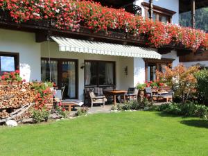 a house with flowers on the side of it at Apartment Tyrol-1 by Interhome in Aschau