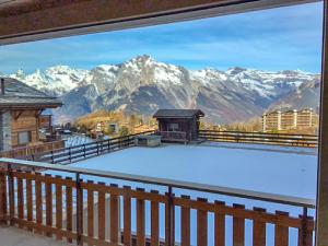 een balkon met uitzicht op een met sneeuw bedekte berg bij Studio Grenier 5 by Interhome in Nendaz