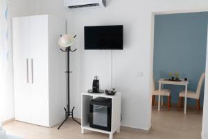 a living room with a tv on a white wall at DIMORA ROSSA in Sottomarina