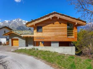 una cabaña de madera con una montaña en el fondo en Chalet Woovim 8 by Interhome en Nendaz