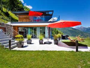 a house on a hill with a red umbrella at Apartment Zenkei by Interhome in Leontica