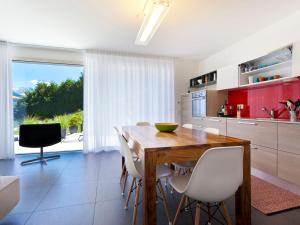 a kitchen with a wooden table and white chairs at Apartment Zenkei by Interhome in Leontica +29 photos