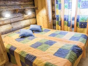 a bedroom with a bed with a colorful quilt at Holiday Home Kelovalta 7b by Interhome in Ruka