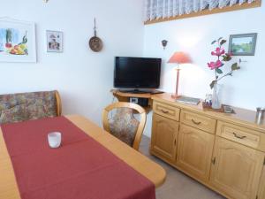 a room with a table and a television and a table and chairs at Apartment Schwarzwaldblick-26 by Interhome in Obertal