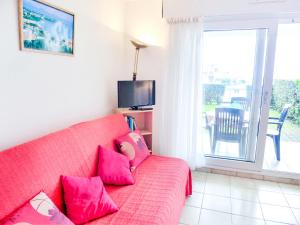 sala de estar con sofá rojo y almohadas rosas en Apartment Zirlinga-7 by Interhome, en Bidart