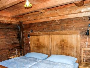 uma cama num quarto com uma parede de madeira em Holiday Home Rustico Cà dru Lurenz by Interhome em Malvaglia