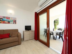 a living room with a couch and a sliding glass door at Apartment Panorama 5 by Interhome in Tanaunella