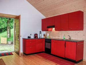 a kitchen with red cabinets and an open door at Holiday Home La Cassìna by Interhome in Bellinzona