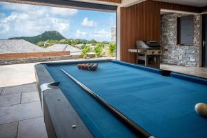 a pool table on the balcony of a house at Les villas de Sweet Hill in Saint Barthelemy