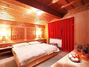 1 dormitorio con 1 cama grande y cortina roja en Apartment Ainhauser-3 by Interhome en Rodund