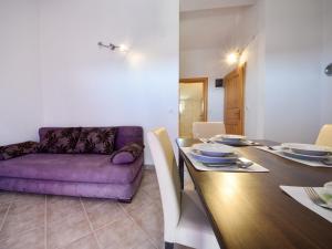 une salle à manger avec un canapé violet et une table dans l'établissement Apartment Milin-3 by Interhome, à Jezera