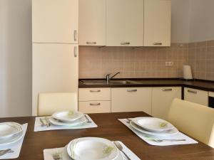 - une cuisine avec des plats blancs sur une table en bois dans l'établissement Apartment Milin-3 by Interhome, à Jezera