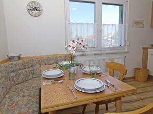einen Tisch mit Tellern und Besteck im Wohnzimmer in der Unterkunft Holiday Home Romy by Interhome in Mannsdorf an der Donau