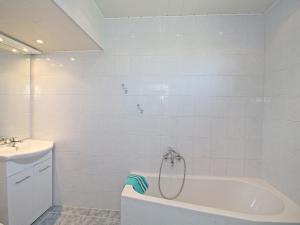 a white bathroom with a tub and a sink at Holiday Home Romy by Interhome in Mannsdorf an der Donau