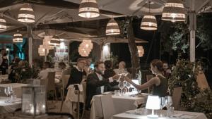 a group of people sitting at tables with wine glasses at Marina di Scarlino Resort in Puntone di Scarlino