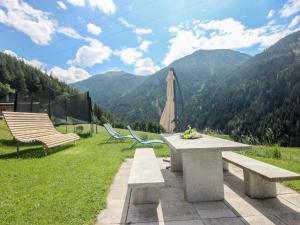 a picnic table and chairs with a view of mountains at Apartment Susi by Interhome in Flirsch