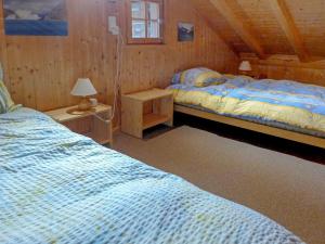 a bedroom with two beds in a wooden cabin at Apartment Rondeau by Interhome in Zinal